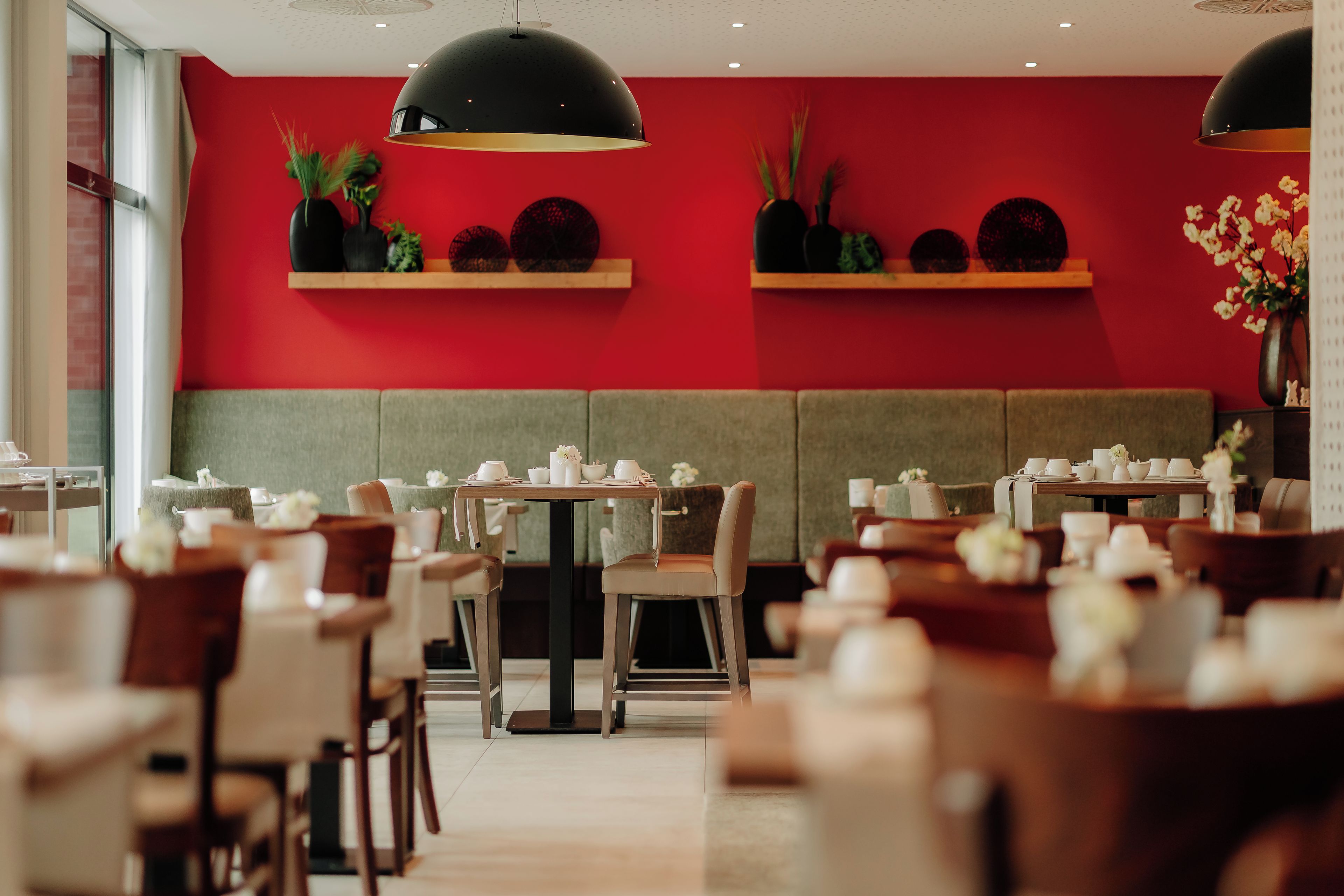 A restaurant interior with booths, tables, and hanging pendant lights.