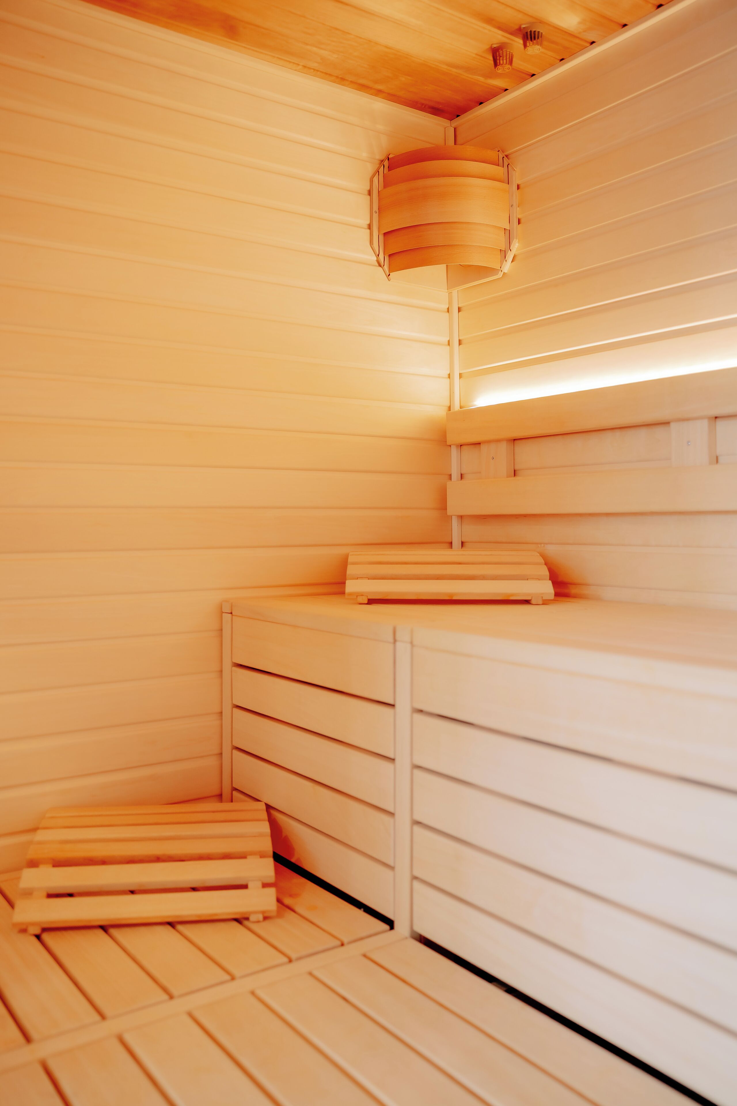 A sauna room with wooden benches and a slatted floor.