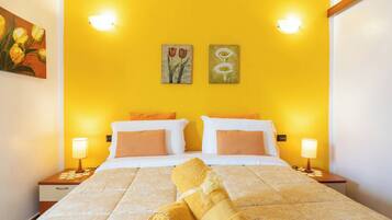 A hotel room with a bed, two bedside lamps, and two wall-mounted light fixtures.