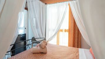 A hotel room with a bed, a desk, and a chair.