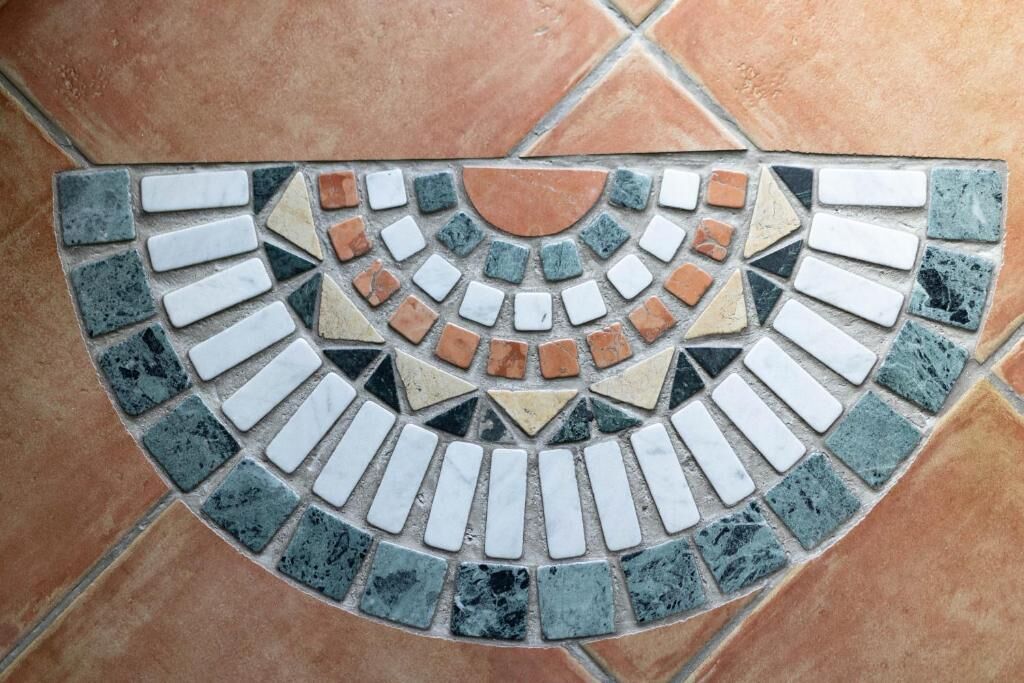Un motif de mosaïque composé de carreaux disposés en forme circulaire.