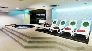 A spa area with a hot tub, lounge chairs, and a view of the outdoors. - Best Western Bucovina-club De Munte (Gura Humorului)
