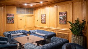 A room with a large sectional sofa, a small table, and wooden paneling on the walls. - Best Western Bucovina-club De Munte (Gura Humorului)