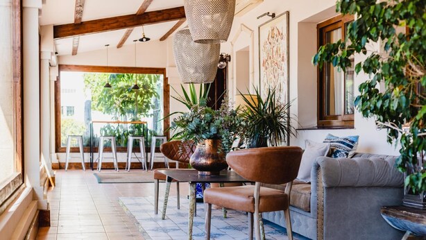 Un salon confortable avec un canapé, des fauteuils, une table basse et un vase décoratif.