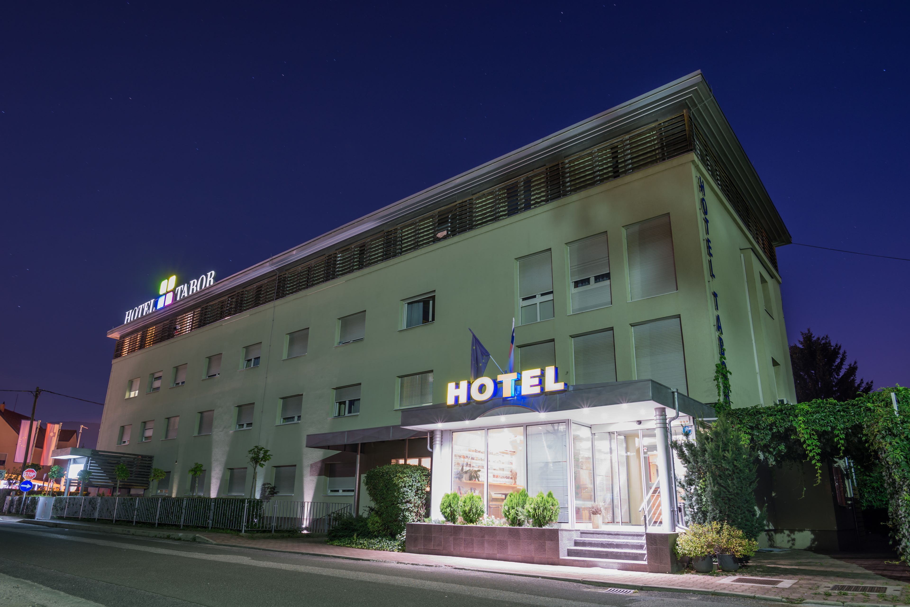 A hotel with a modern facade, multiple windows, and a well-lit entrance.