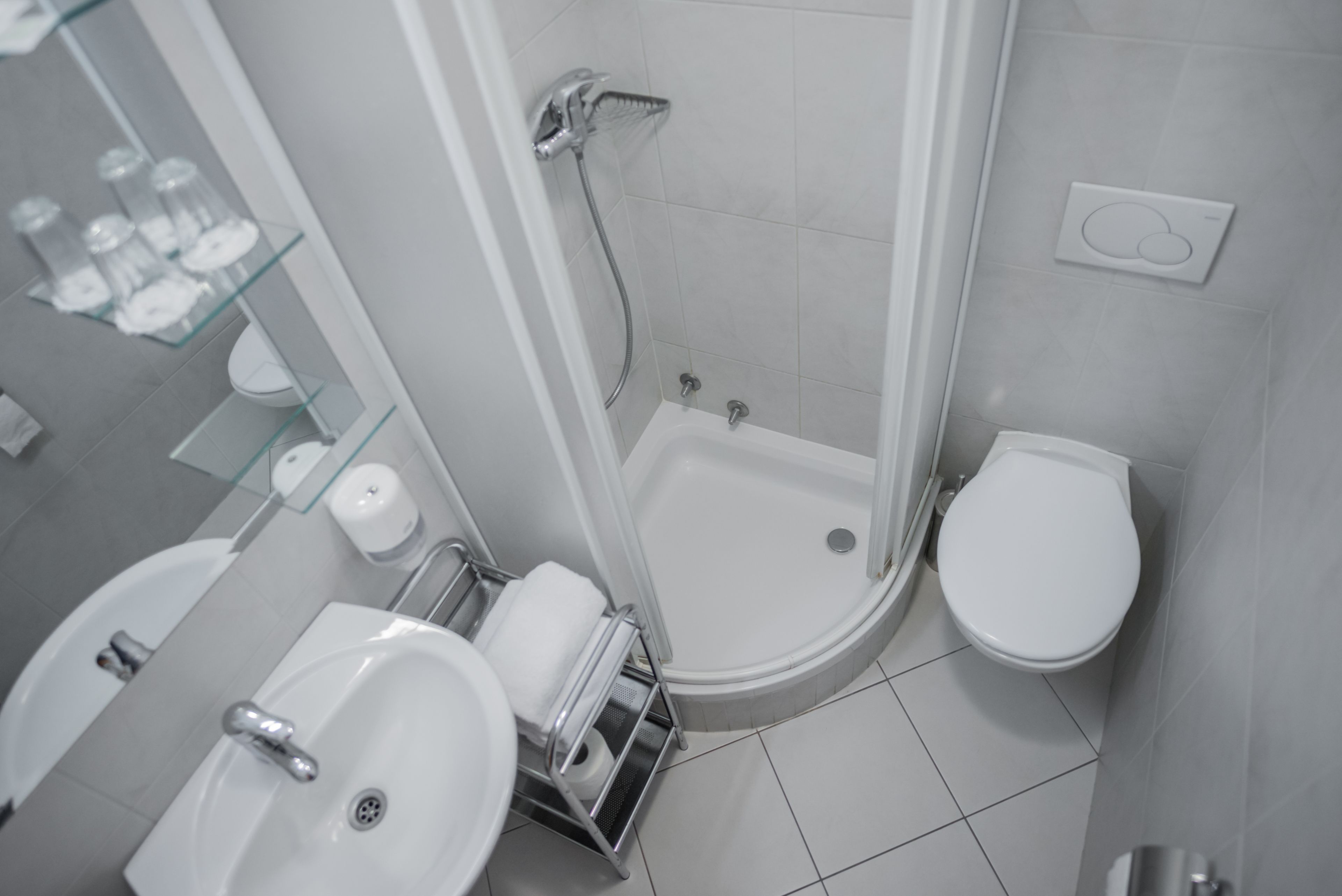 A modern bathroom with a shower, toilet, and two sinks.
