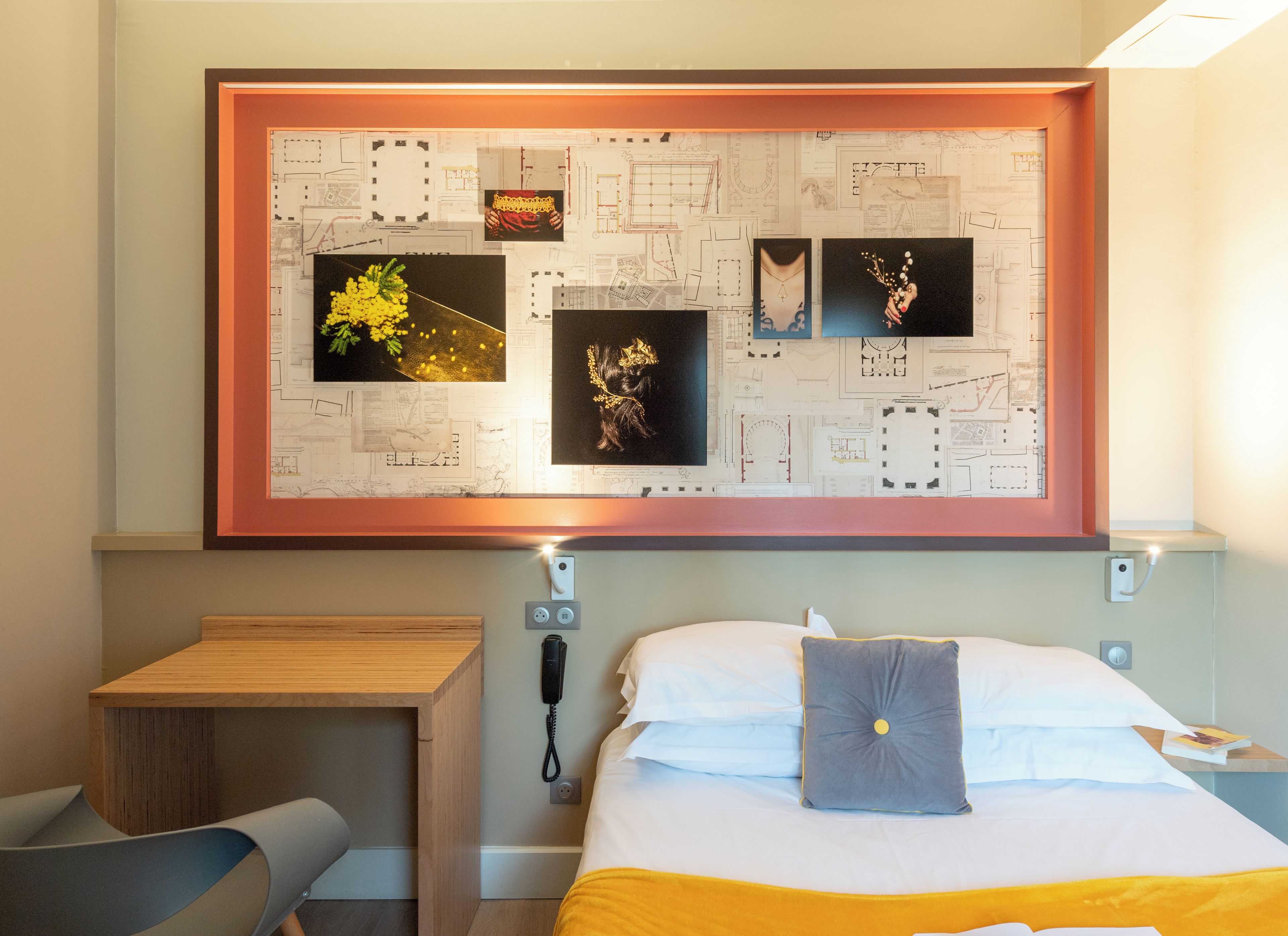 Ein Hotelzimmer mit einem Bett, einem Nachttisch, einem Sessel und einem Wandbild.