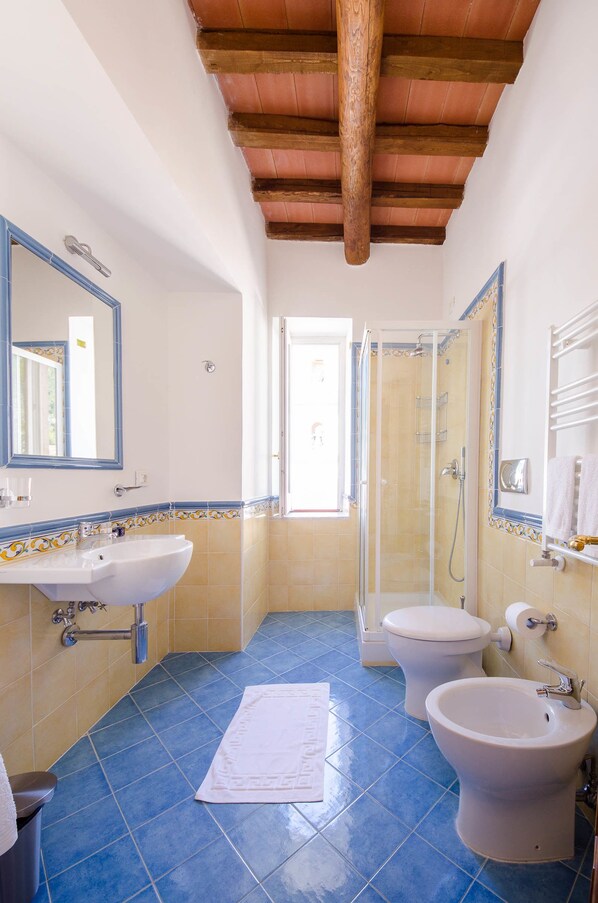 A bathroom with a sink, bidet, toilet, and shower. - Villa Isabella (Minori)