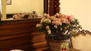 A wooden dresser with a mirror, a basket of flowers, a cup, and books. - Luna Caprese (Naples)