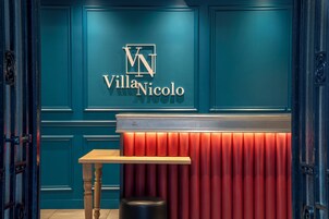 A reception area with a teal wall, a wooden table, and a red seating area.