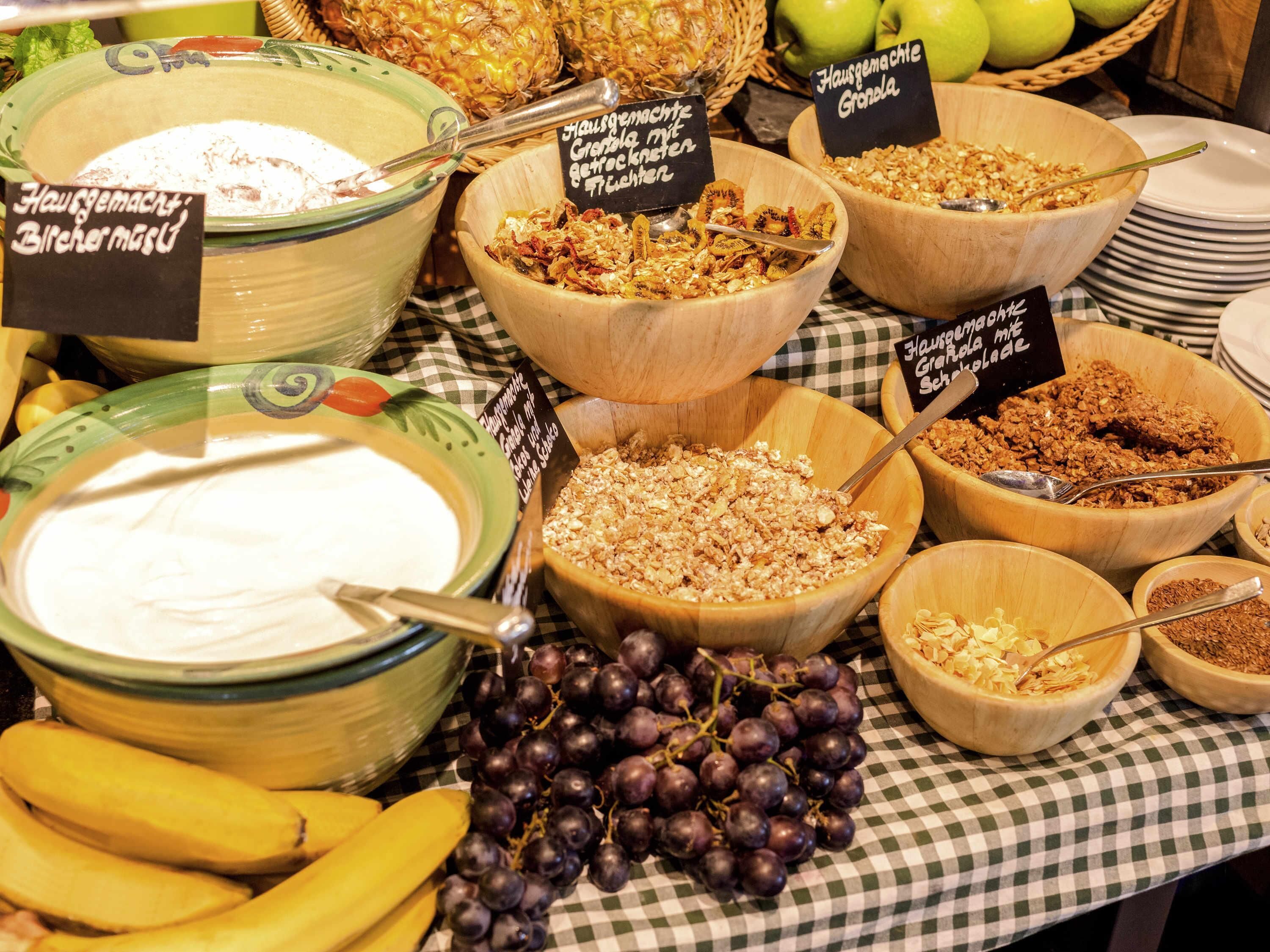 A breakfast buffet with various food options including yogurt, granola, and fruits.