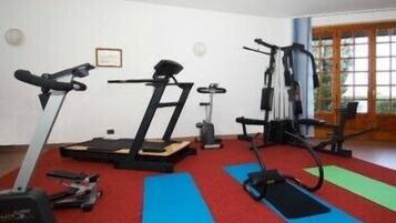 Een fitnessruimte met loopbanden, elliptische trainers en gewichttoestellen.