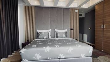 A modern bedroom with a large bed, a wardrobe, and a built-in TV.