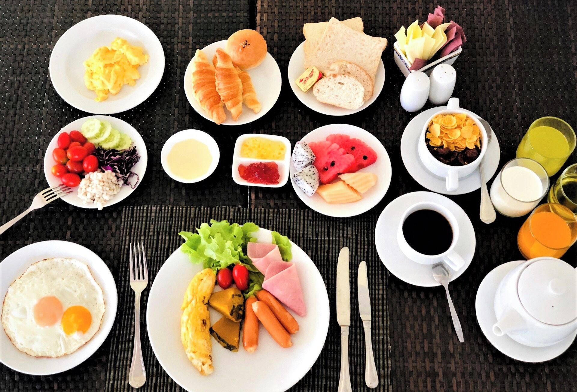 A breakfast spread with various dishes and drinks on a table.
