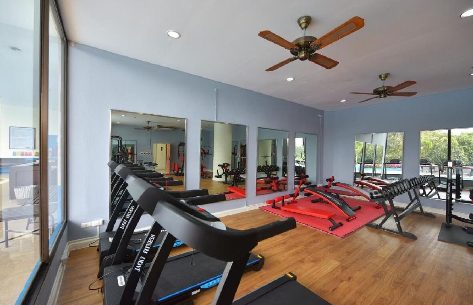 A gym with treadmills, weight machines, and mirrors.