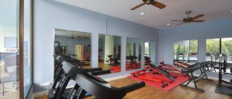 A gym with treadmills, weight machines, and mirrors.