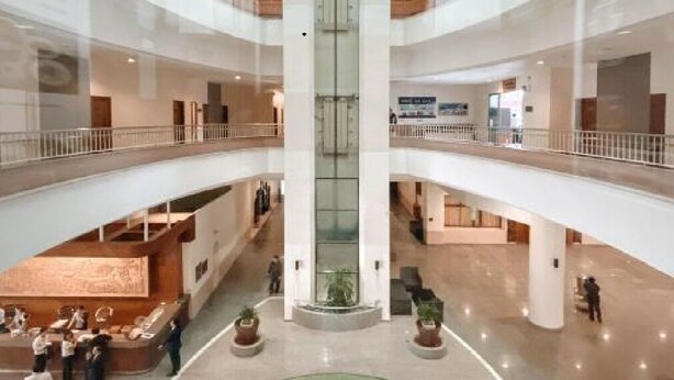 A multi-level atrium with a central fountain, glass railings, and a modern design.