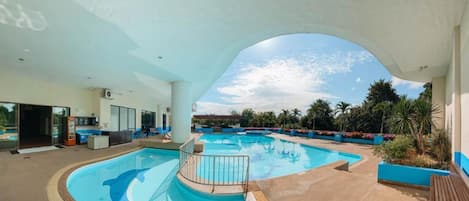 Alberca techada, alberca al aire libre y camastros