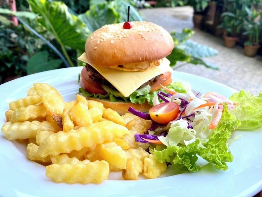 Een bord met een hamburger, frietjes en een salade.