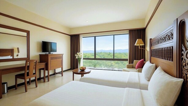 Una habitación de hotel con una cama grande, un escritorio con televisor y vistas al exterior.
