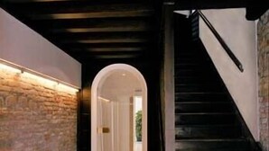 A hallway with a stone wall on one side and a staircase on the other. - Palazzo Soderini (Venice)