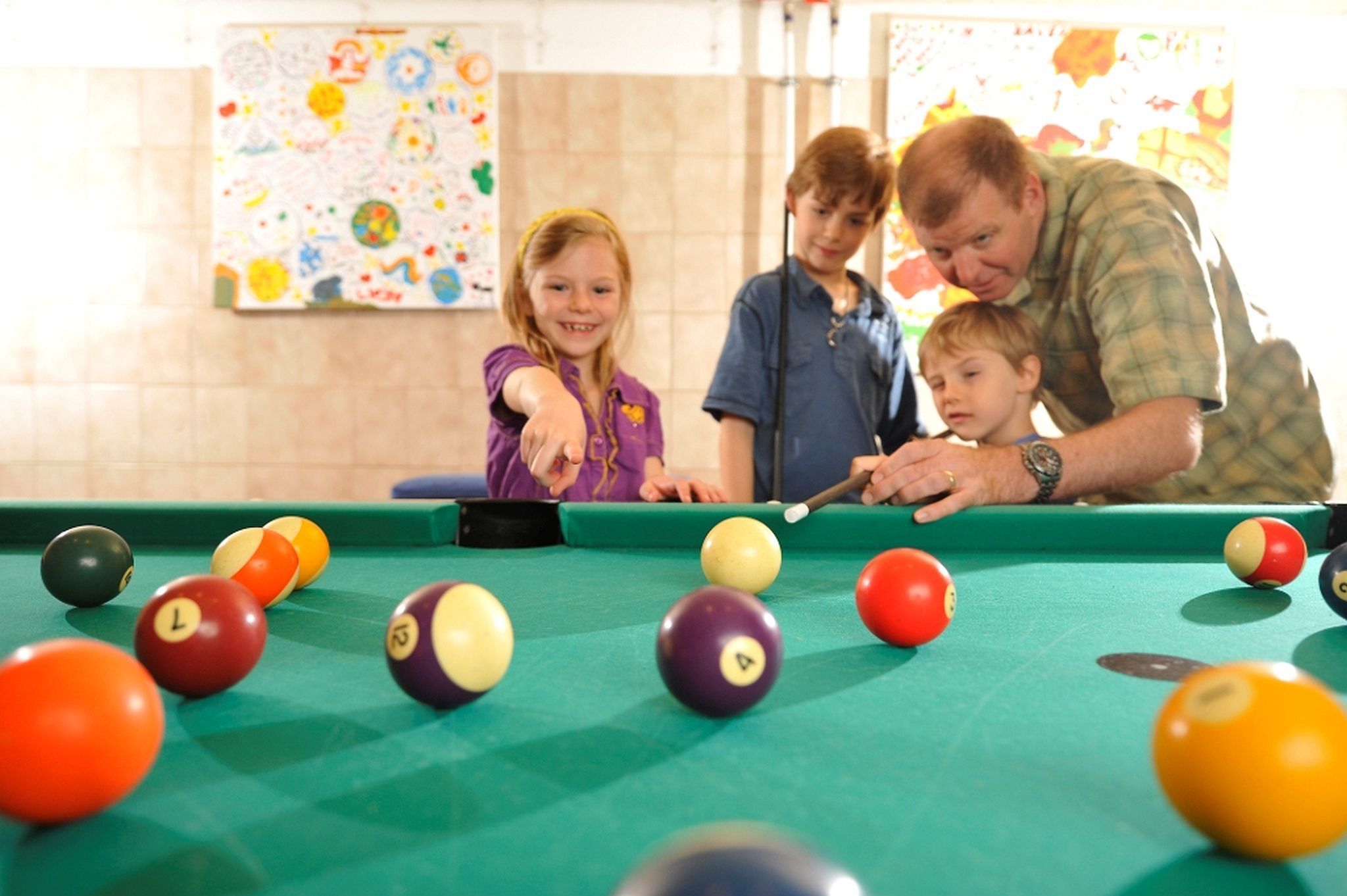A pool table with balls and a person playing.