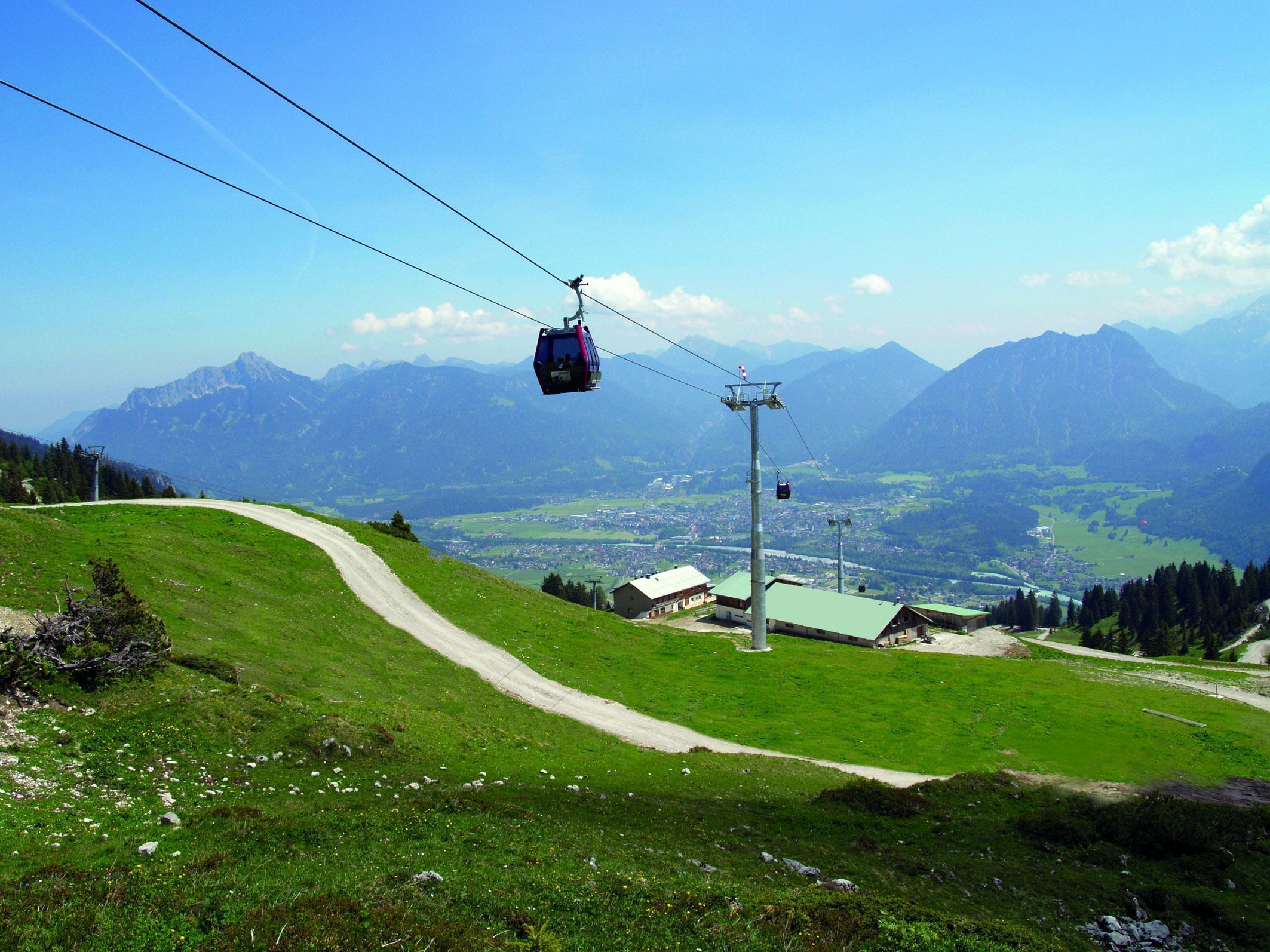 Eine Seilbahn in einer Berglandschaft mit freiem Blick ins Tal.
