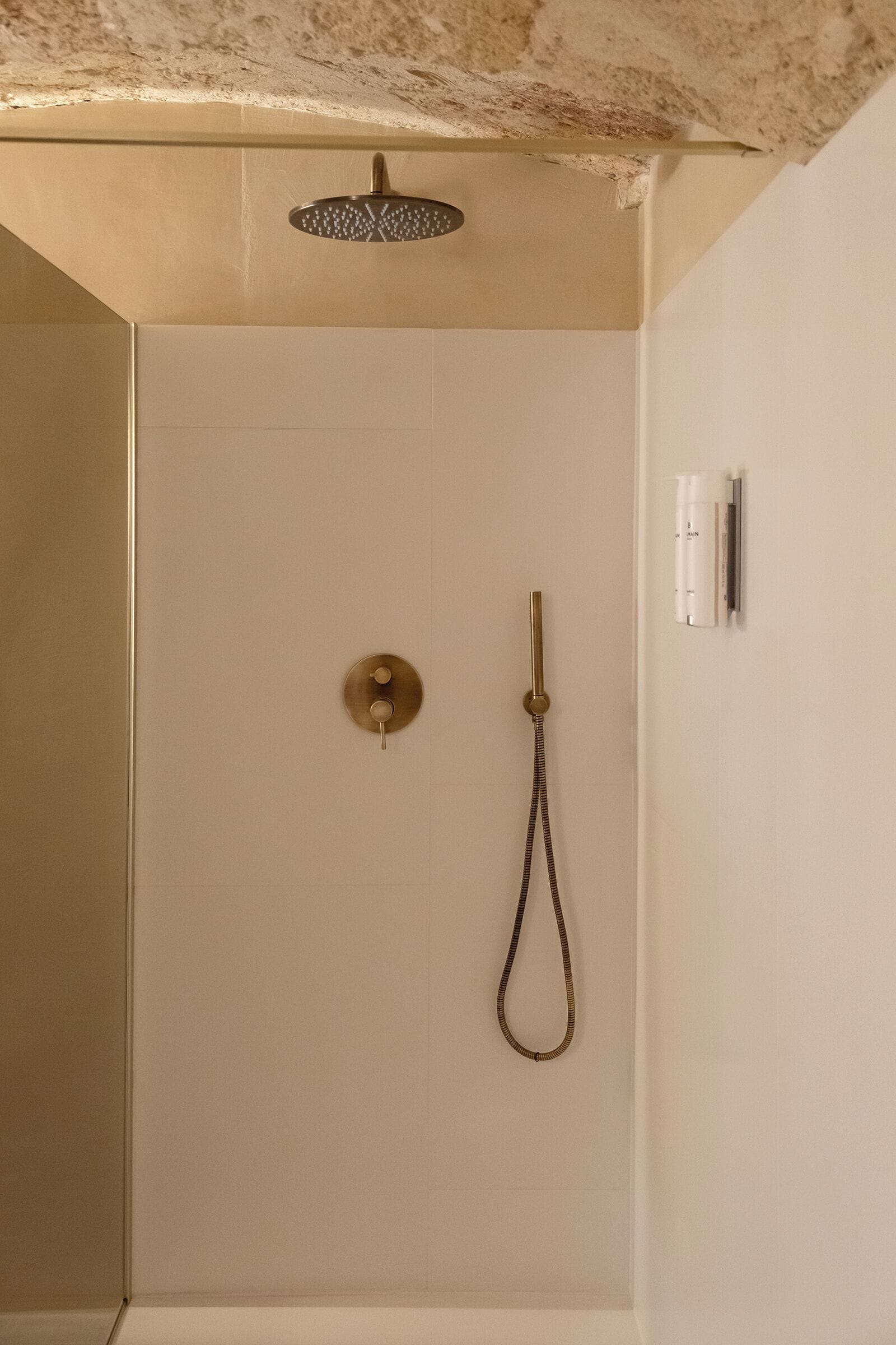 Een douche met douchekop en handdouche.