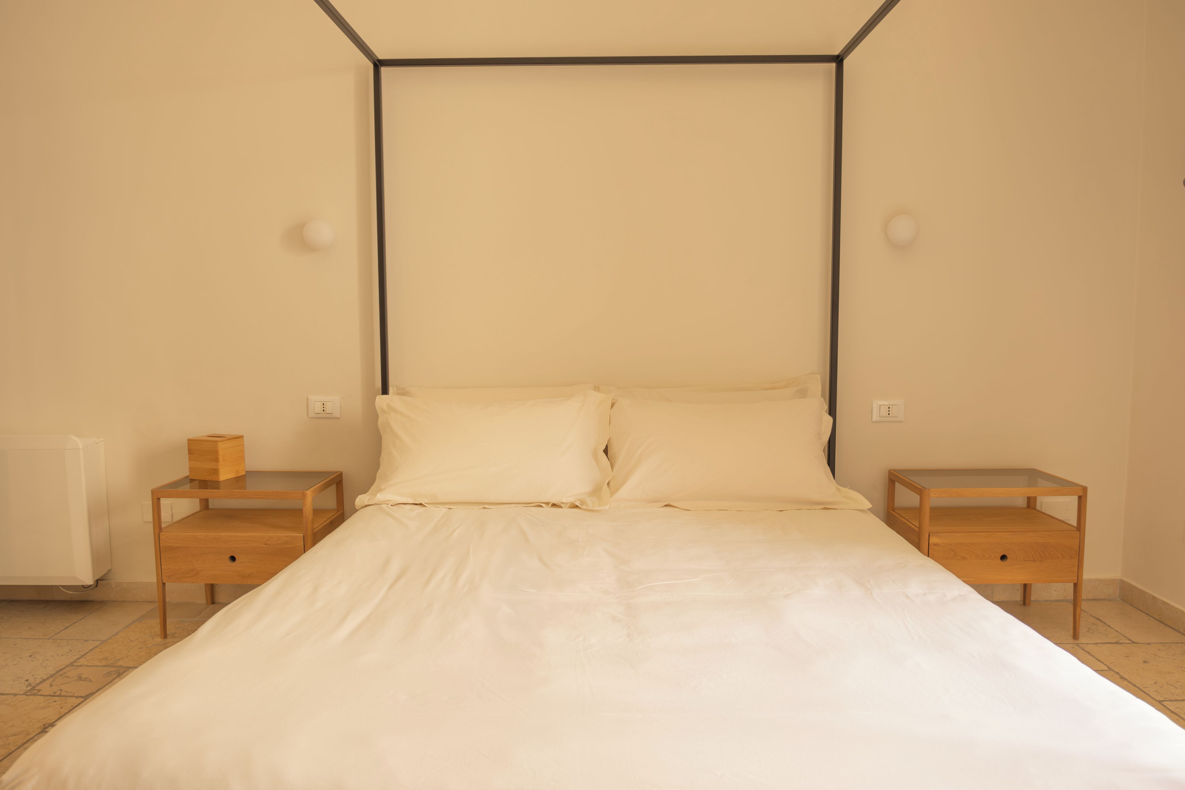 Ein Schlafzimmer mit einem Bett, zwei Nachttischen und einer Heizung.