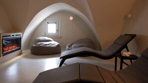 Una habitación acogedora y moderna con chimenea, un rincón de estar cómodo y un ventanal pequeño.