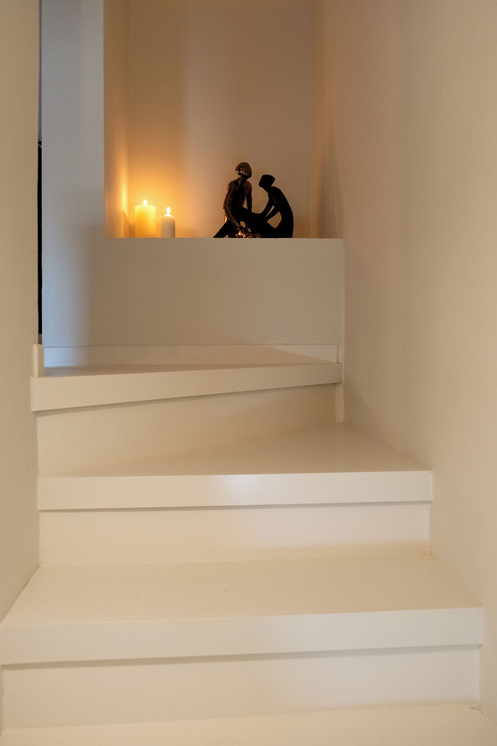 A staircase with white steps leading up to a landing.