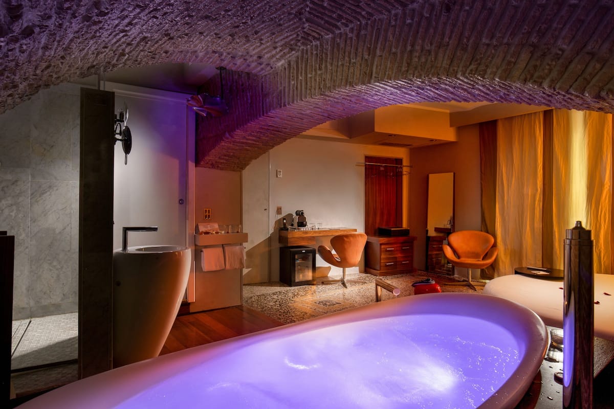 A modern bathroom with a large bathtub, a sink, and a shower area.