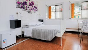 Un dormitorio con cama, escritorio y radiador.