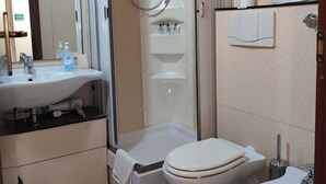 Un baño pequeño con lavabo, inodoro, bidé y ducha.