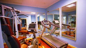 A gym with exercise equipment, a treadmill, and mirrors on the walls. - Grand Hotel Arciduca (Lipari)
