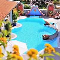 Una piscina al aire libre, sombrillas, sillones reclinables de piscina