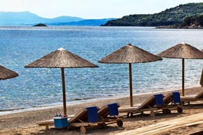 Gần bãi biển, ghế dài tắm nắng, dù trên bãi biển, khăn tắm biển 