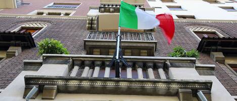 Exterior del Hotel Palladio con un asta de bandera y una señal.