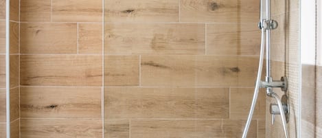 Una ducha moderna con puerta de vidrio y revestimiento de madera.