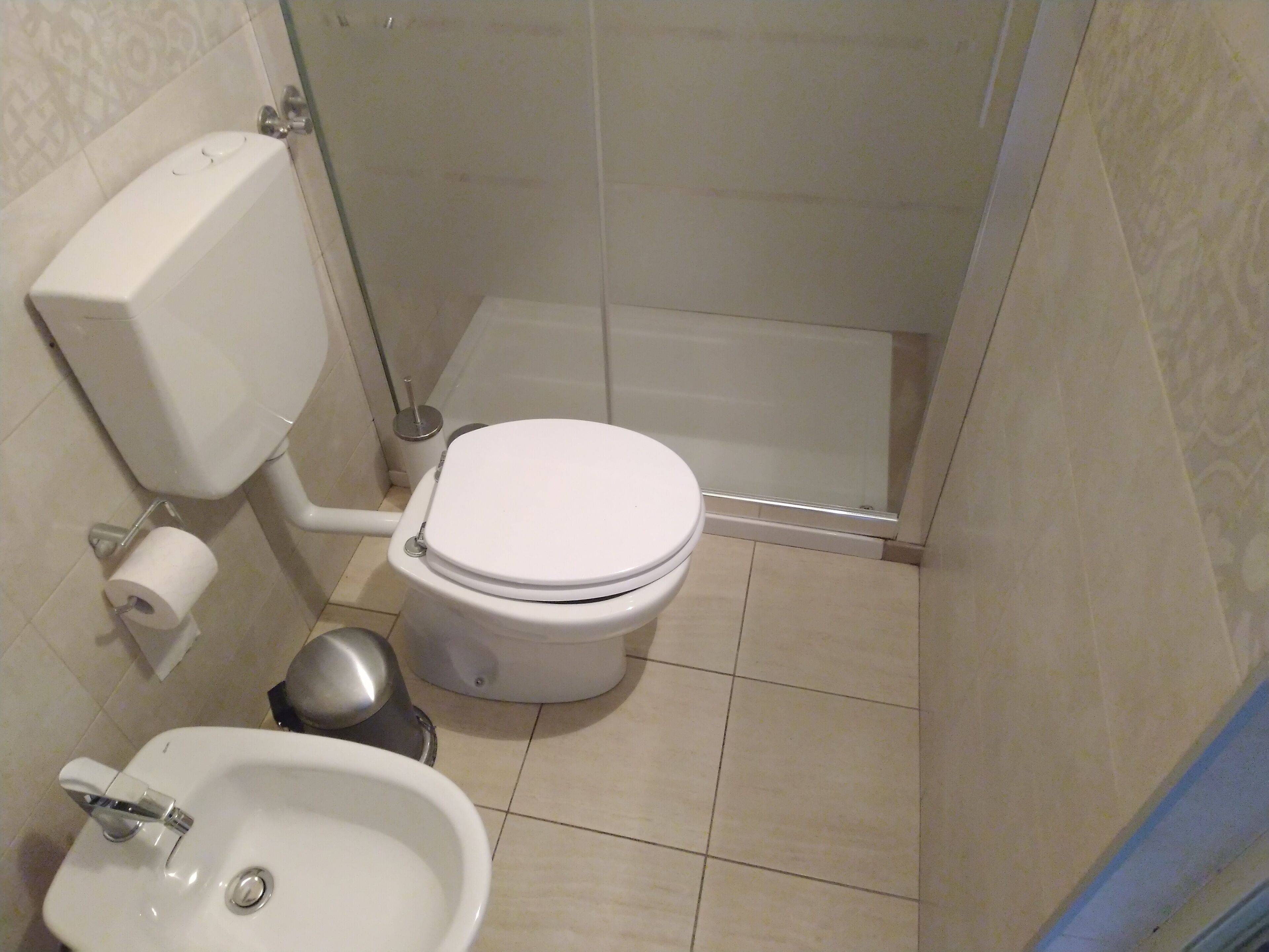 A small bathroom with a toilet, bidet, and sink.