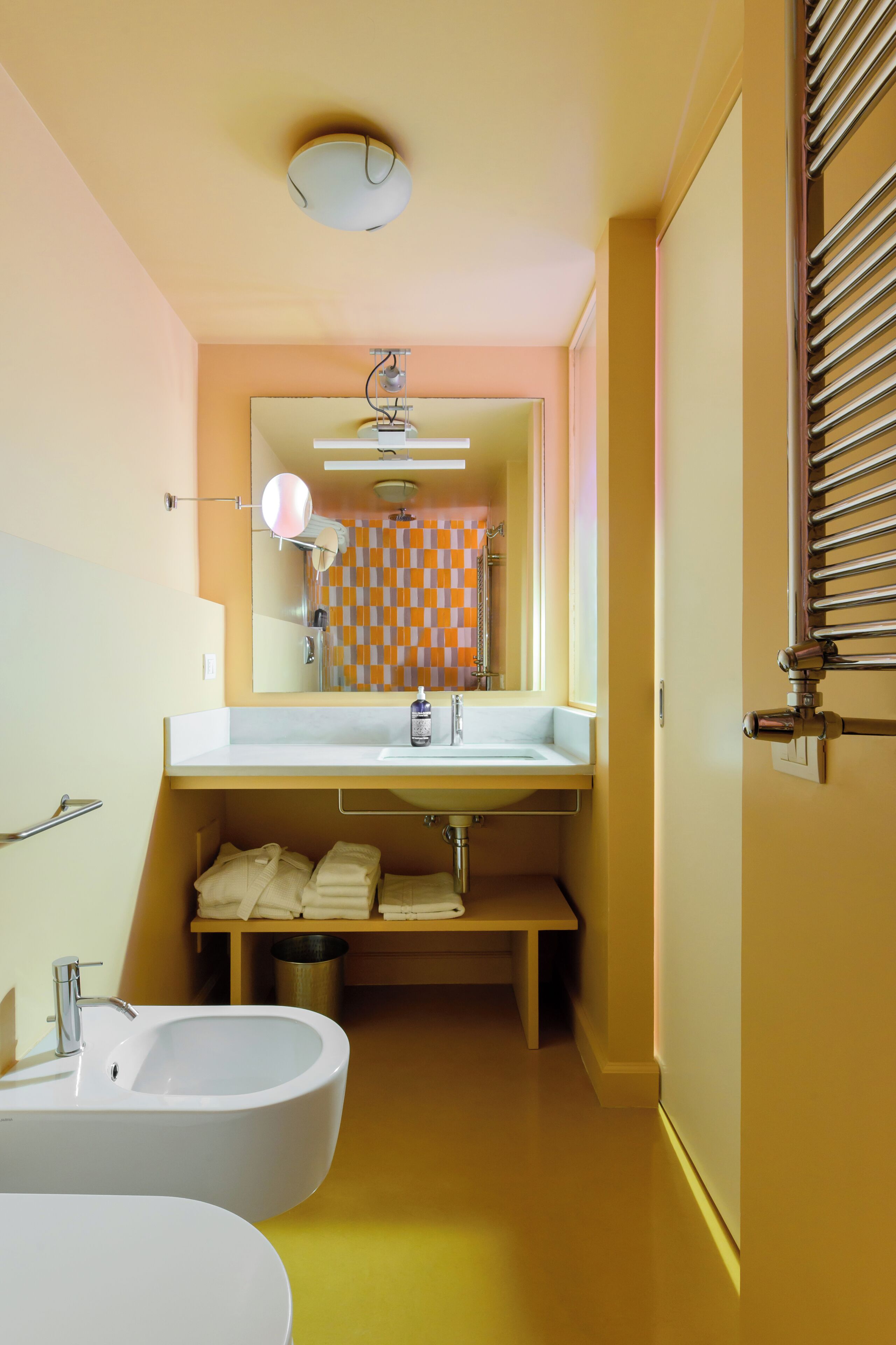 A bathroom with a bathtub, sink, and a towel rack.