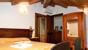 A bedroom with a bed, wooden headboard, a chair, a dresser, and a mirror. - Villa San Giacomo (Scerni)