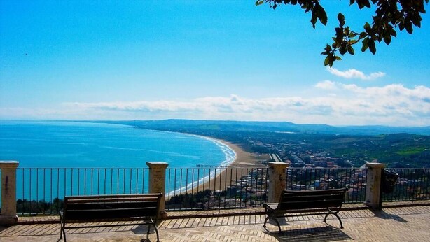 A paved viewing platform with two benches overlooking a coastal cityscape. - Villa San Giacomo (Scerni)