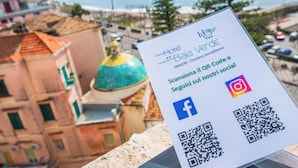 Skilt for Hotel Baia Verde med QR-kode, Facebook- og Instagram-ikoner.