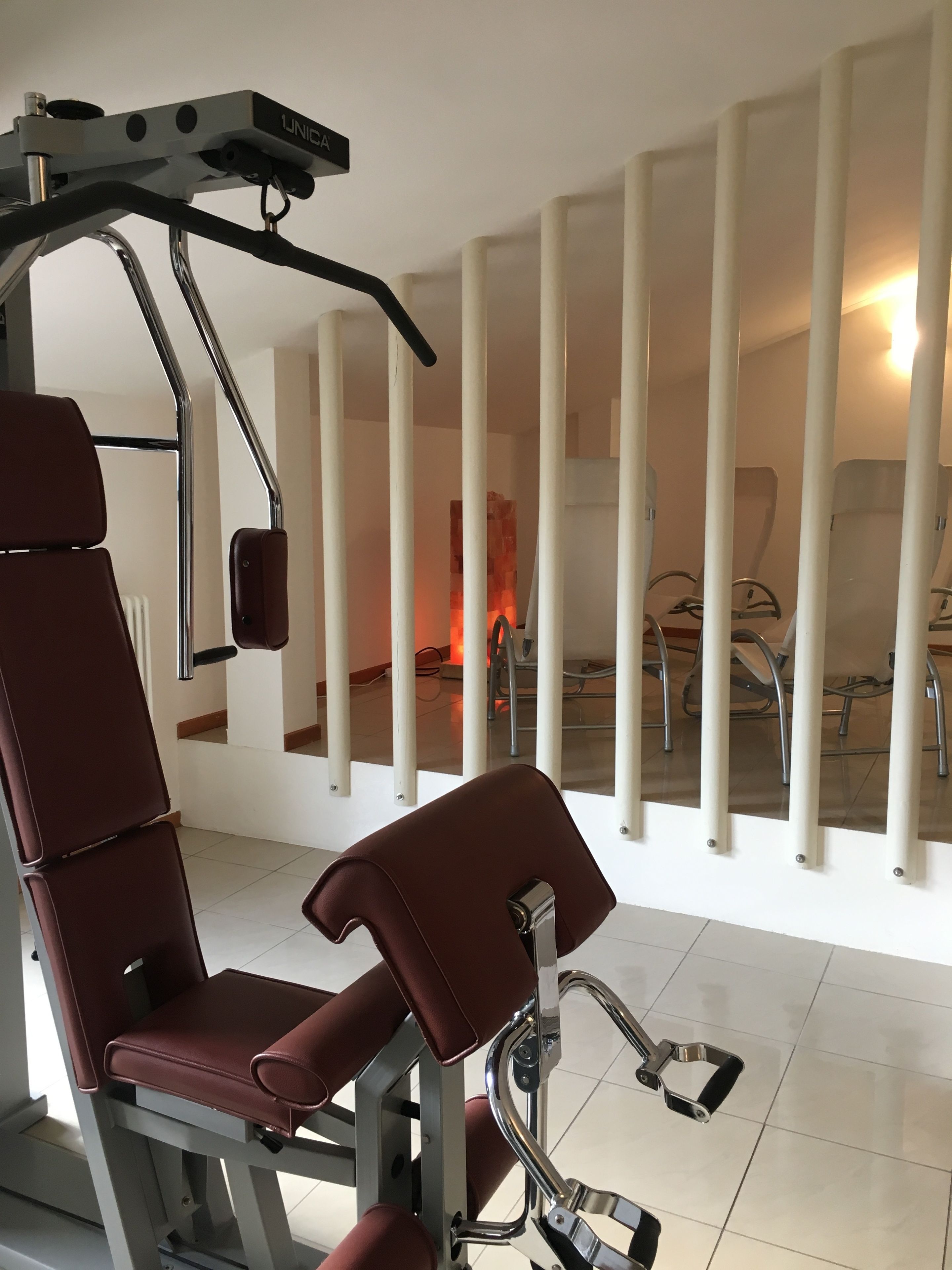 Un gimnasio con equipo de ejercicio, que incluye una máquina de pesas y una banca.