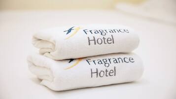 Two folded towels with embroidered text reading "Fragrance Hotel."