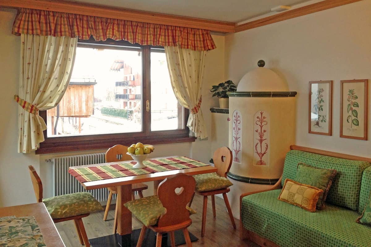 Un salon chaleureux avec une table à manger, des chaises, un canapé et un radiateur.