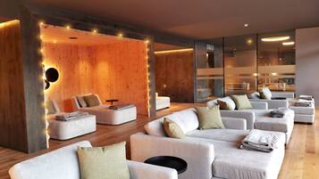 Relax in a stylish space with a seating area, circular light fixture, and large mirror.