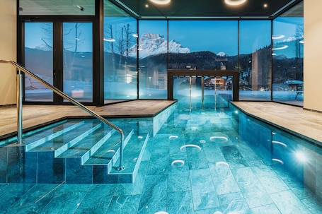 Una piscina techada, sillones reclinables de piscina