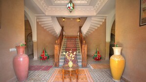 A grand staircase with intricate designs, leading to a high-ceilinged area with a chandelier. - Villa Dar Mya Palmiers (Marrakech)
